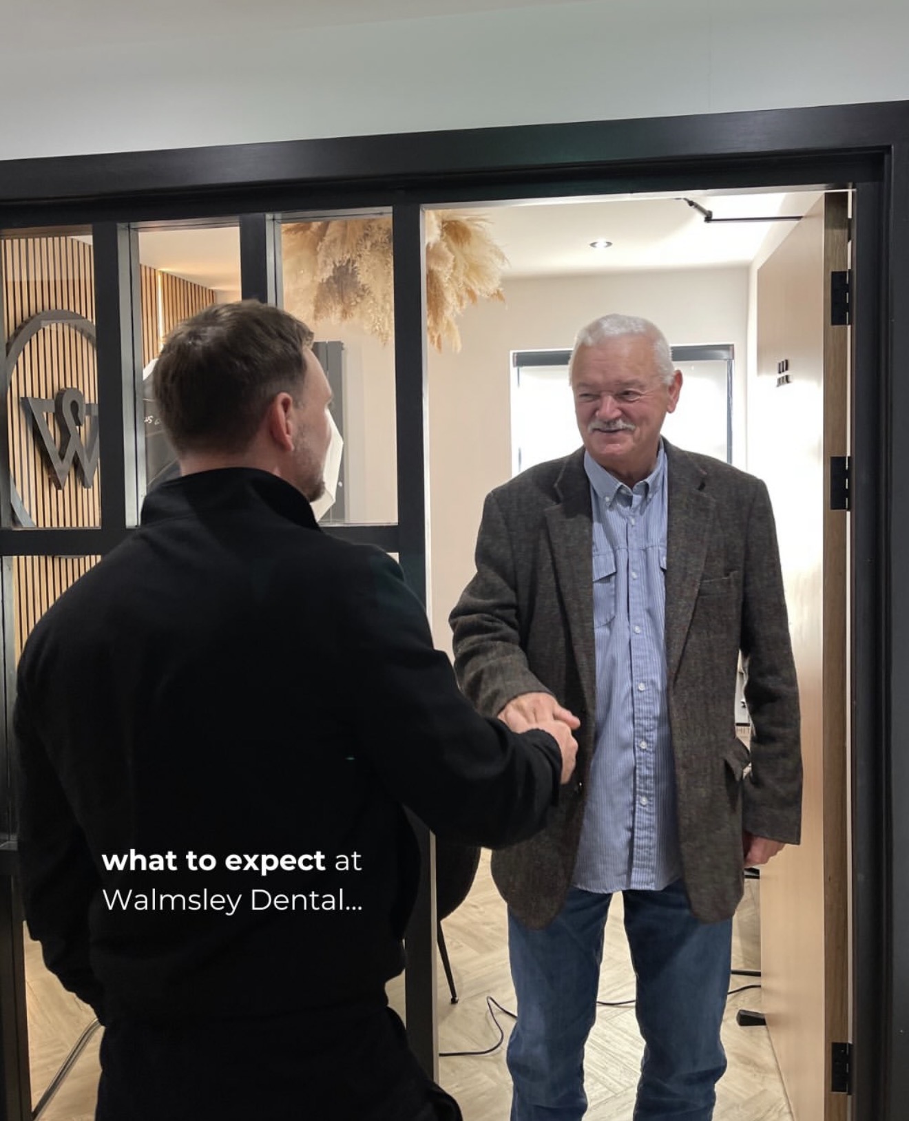 Dr Edward Walmsley welcoming a patient at Walmsley Dental, Droylsden